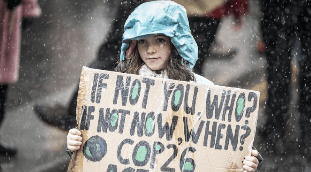 Child holding sign at COP26